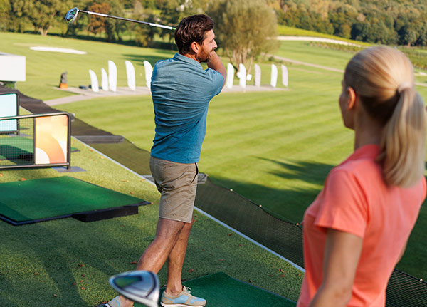 Golfeinsteiger beim Abschlag auf der Driving Range